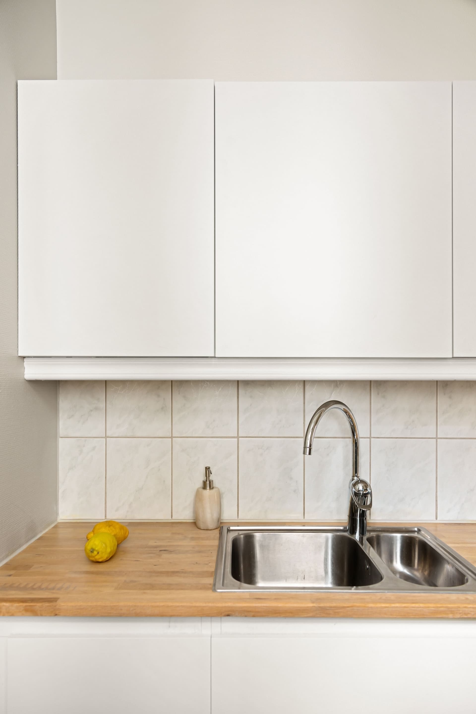 Clean kitchen sink and countertop with white cabinets